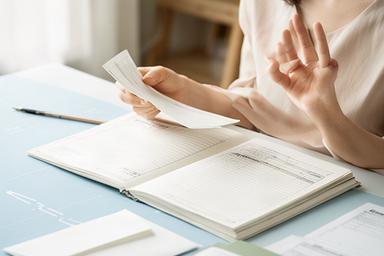 教育費と老後資金の計画をノートに整理する滋賀県の母親